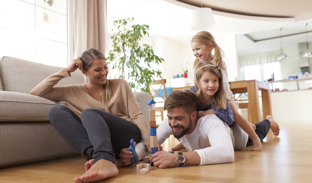 familie leker sammen på et gulv som har gulvvarme